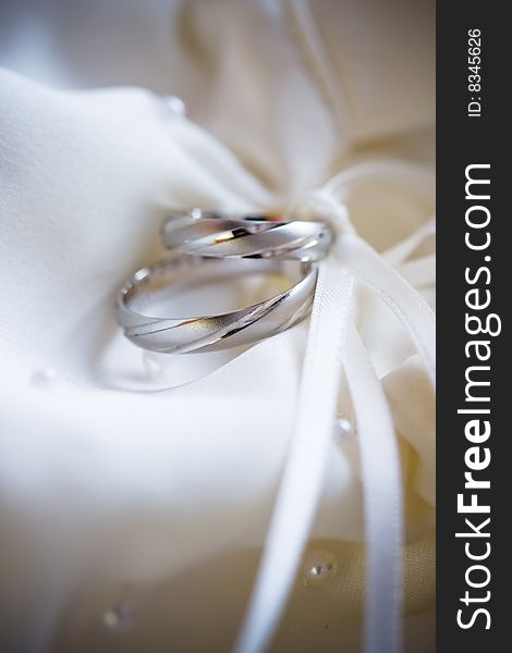 Wedding rings of white gold on a silk background of bride handbag. Wedding rings of white gold on a silk background of bride handbag