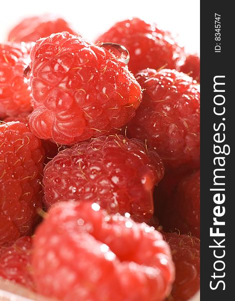 Heap of a lot of fresh raspberries on white background