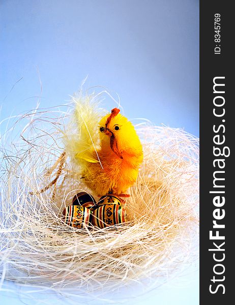 Easter background with decorative toys as a nest with a chicken and eggs