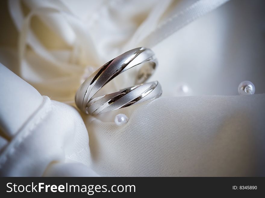 Wedding rings of white gold on a silk background of bride handbag. Wedding rings of white gold on a silk background of bride handbag