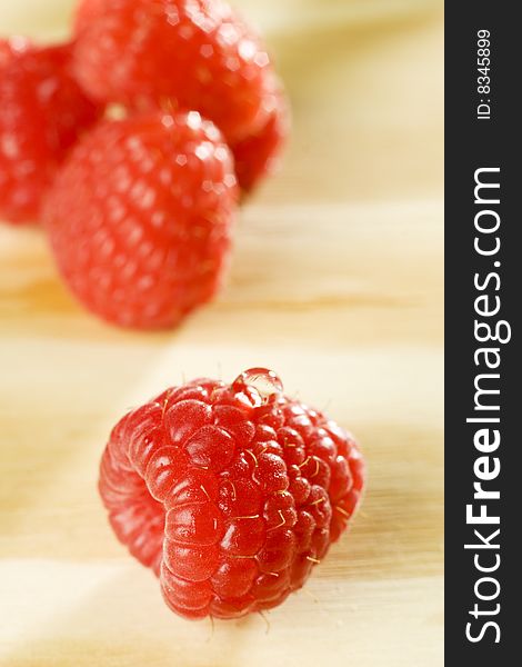 Fresh colorful raspberries on wooden background