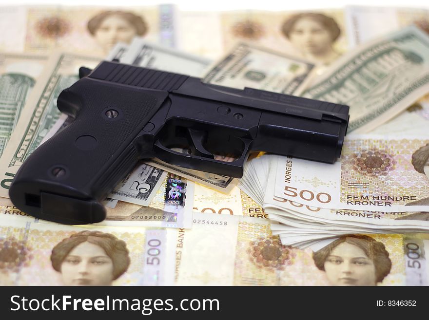 Fine close up image of pistol and dollar background. Fine close up image of pistol and dollar background