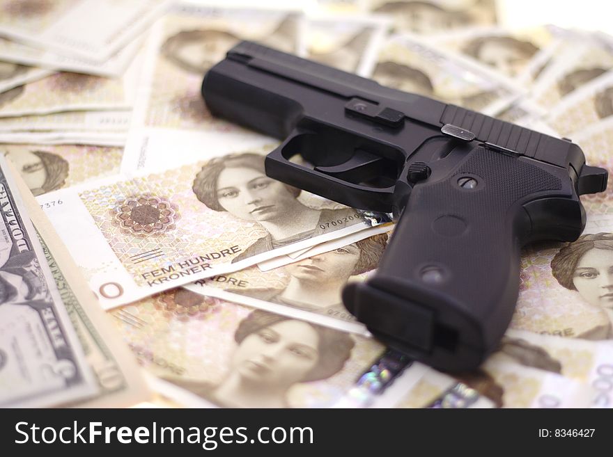 Fine close up image of pistol and dollar background. Fine close up image of pistol and dollar background