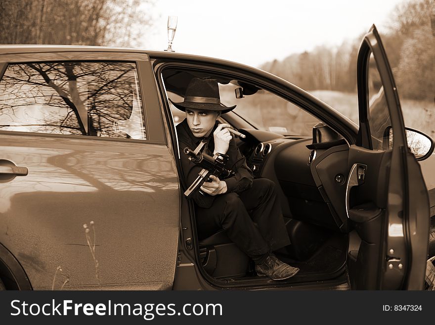 Man in car with cigar and rifle