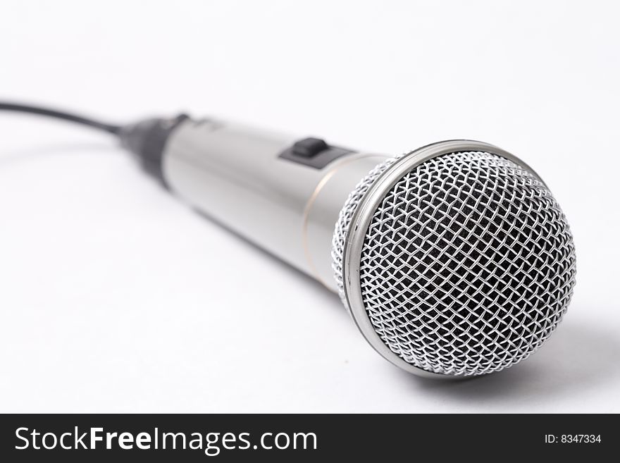 Closeup on metallic microphone over white background. Closeup on metallic microphone over white background