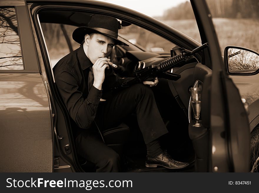 Man in car with cigar and rifle