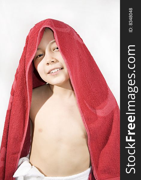 Cheerful boy with the red towel on its head