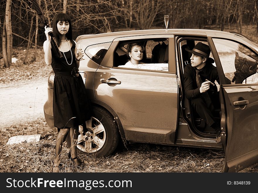 Brunette , man and woman with cigar, wine in car