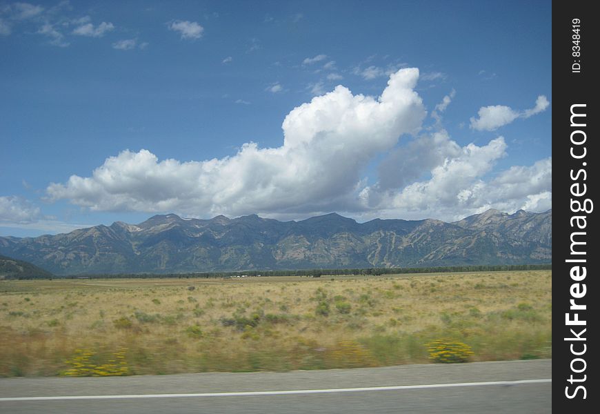 Travel in Wyoming. Clouds, Mountains, Desert and Highway. Travel in Wyoming. Clouds, Mountains, Desert and Highway