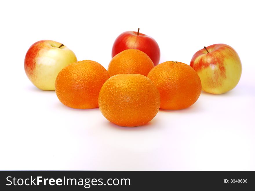 Four mandarines and three apples on a white background