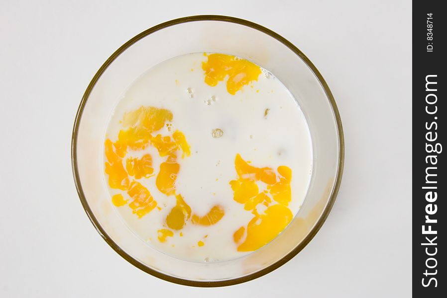 Mix of Raw eggs and mikk in glass bowl.