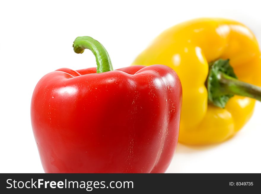 Red and yellow peppers over white. Red and yellow peppers over white