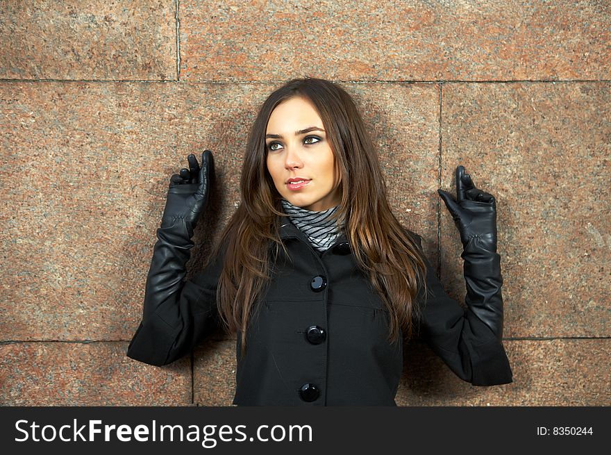 Beautiful woman at a wall with heaved up hands. Beautiful woman at a wall with heaved up hands