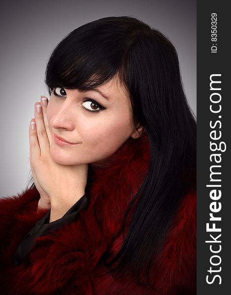 Portrait of brunette is in a red fur coat