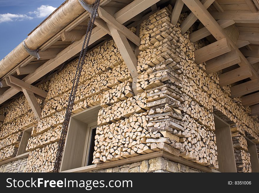 Firewood superposition around the house wall. Firewood superposition around the house wall