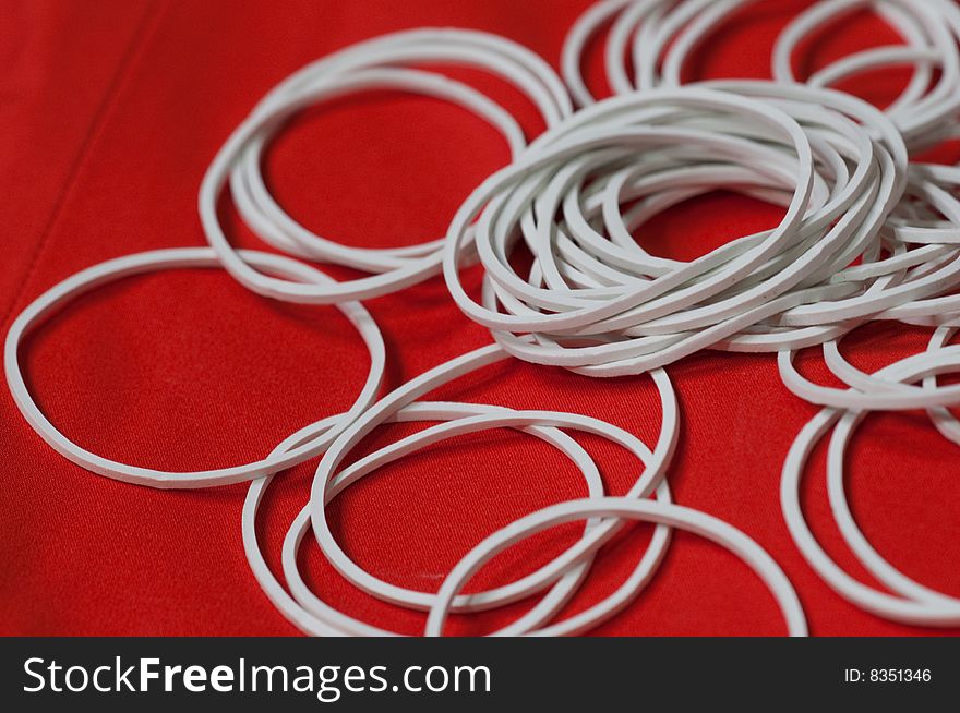 White Elastic bands with red background