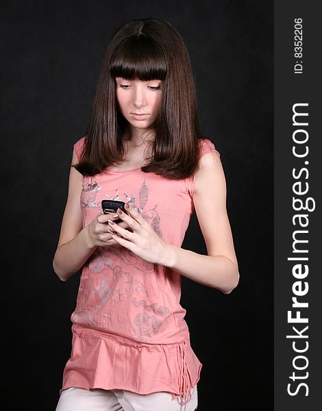 Girl with a phone standing in studio