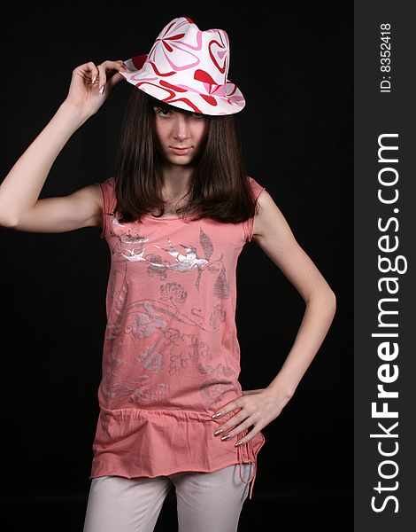 Smiling girl in hat standing in studio