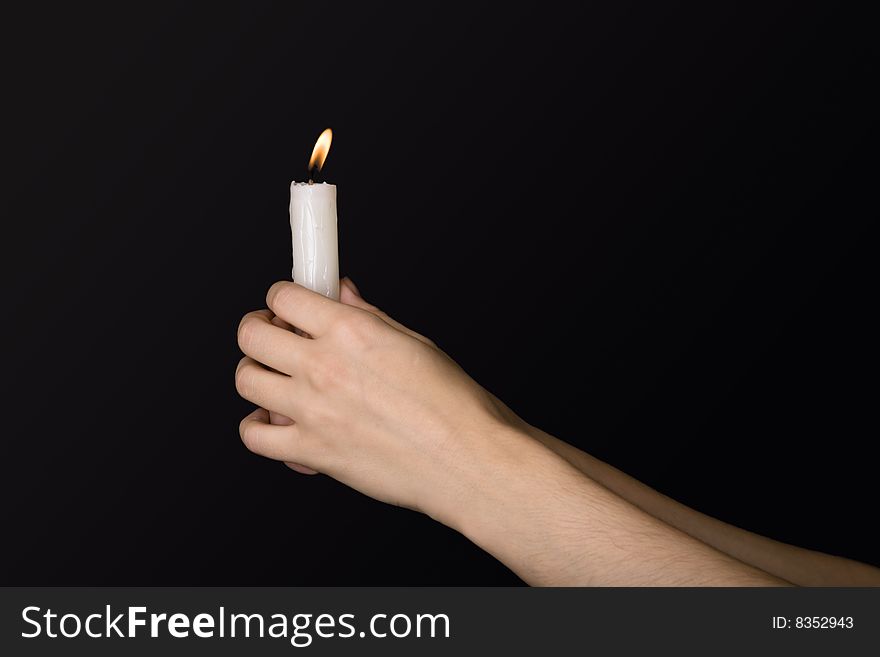 Burning candle in hands