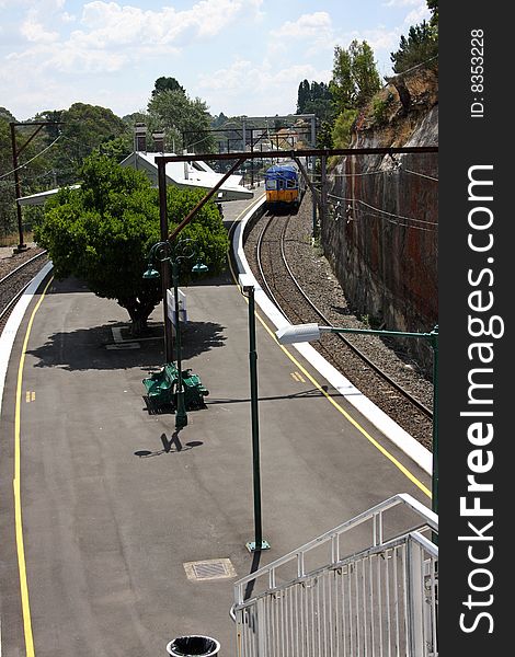 An elevated view of a small rural railway station with an approaching train. An elevated view of a small rural railway station with an approaching train.