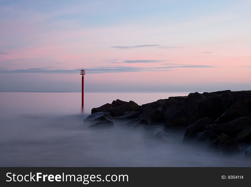 In this photo is buoy near rocks. Was taken in West Bay, Dorset, England.