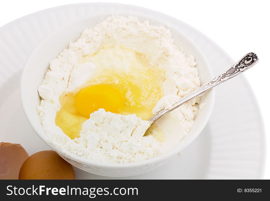 Flour and egg in a bowl, ready to be mixed. Isolated on white. Flour and egg in a bowl, ready to be mixed. Isolated on white.