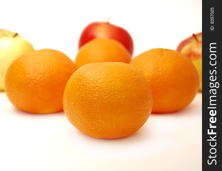 Four mandarines and three apples on a white background