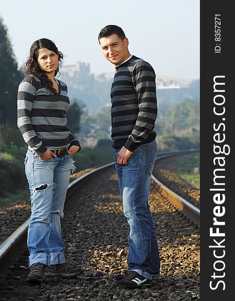 Young couple looking each other on railway tracks. Young couple looking each other on railway tracks