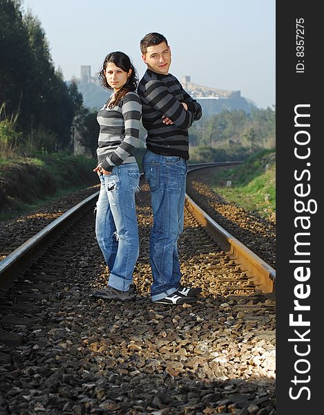 Young couple looking each other on railway tracks. Young couple looking each other on railway tracks