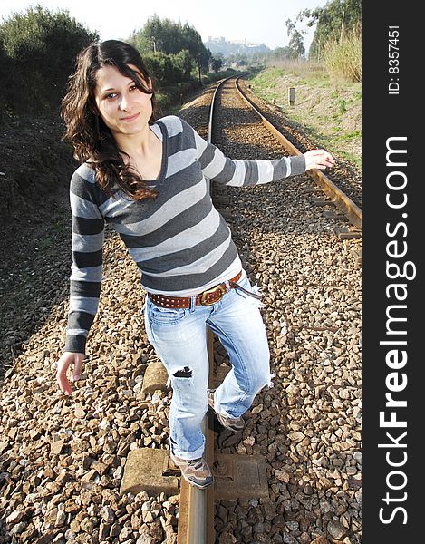 Beautiful girl walking on a railway track