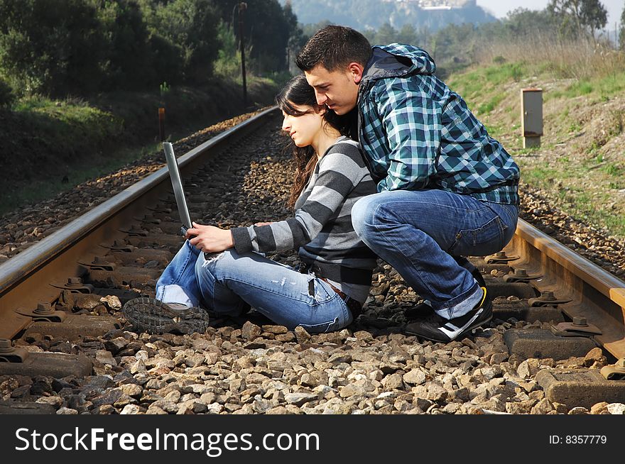 A Young Couple Standing On A Railway