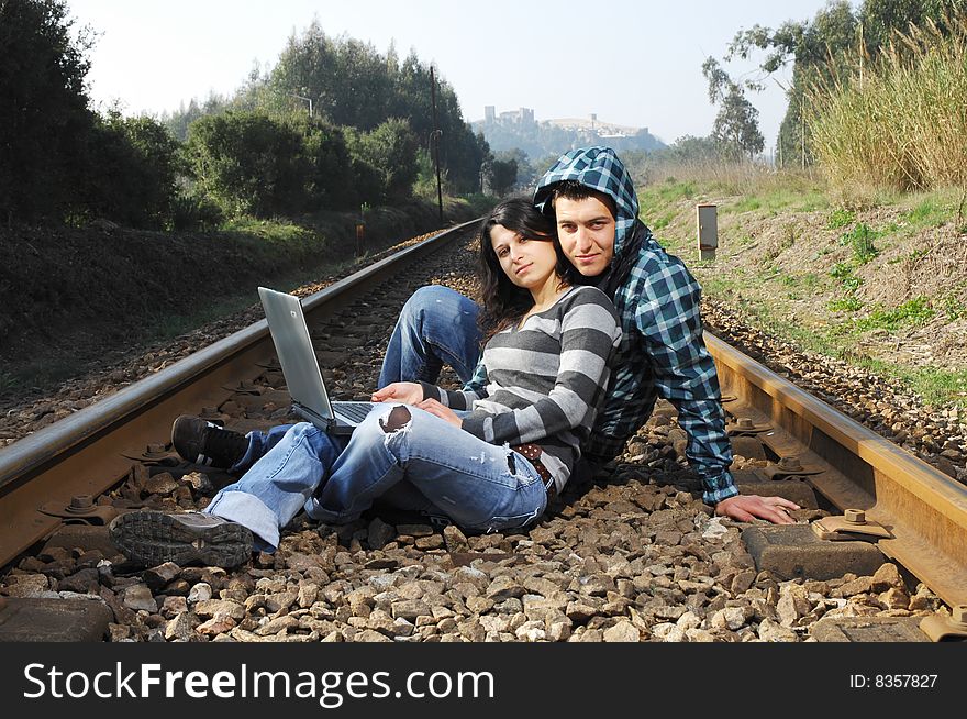 A young couple standing on a railway