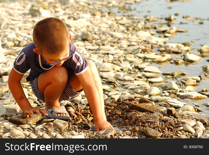 Young boy playing on the river