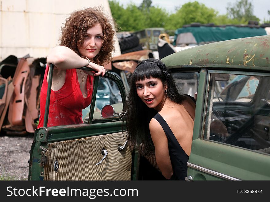 Two girls at vintage cars