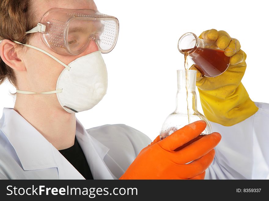 View on scientist in respirator and rubber gloves pours  brown liquid from one flask in another. View on scientist in respirator and rubber gloves pours  brown liquid from one flask in another