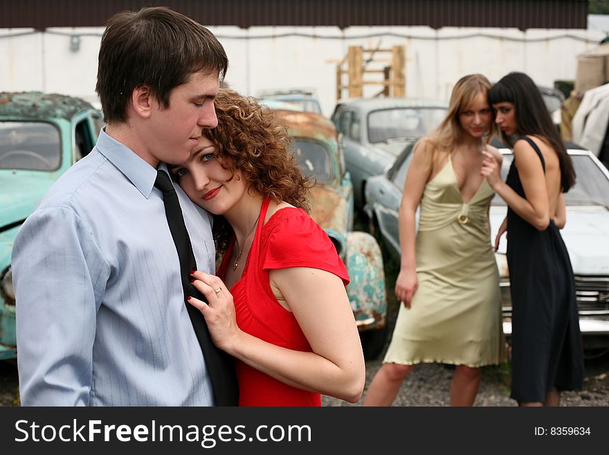 Love and jealousy - couple and two girl beside vintage cars