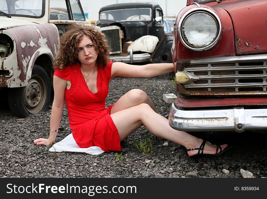 Girl at car under constructions to wheel. Girl at car under constructions to wheel