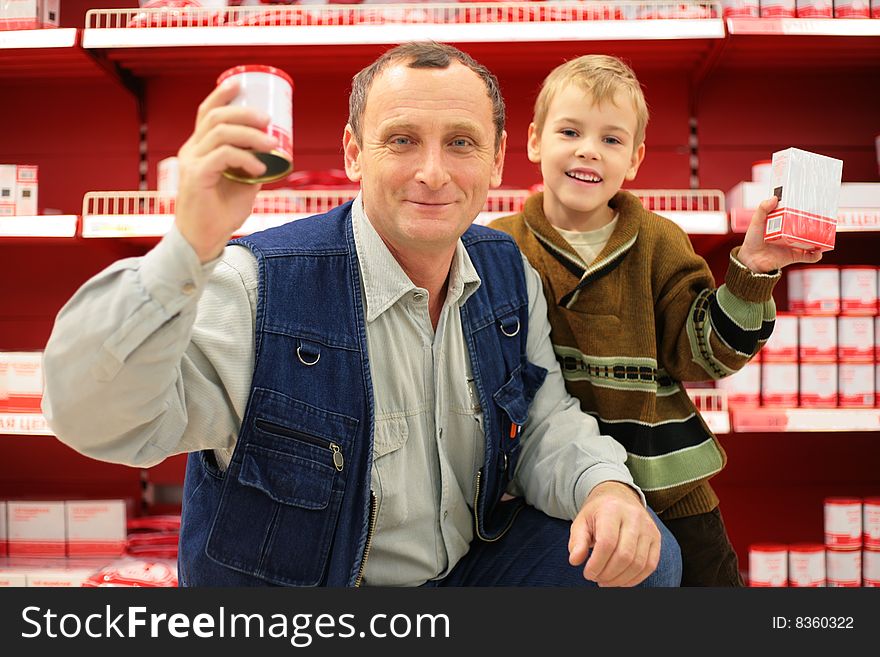 Smiling grandfather and grandson in food shop