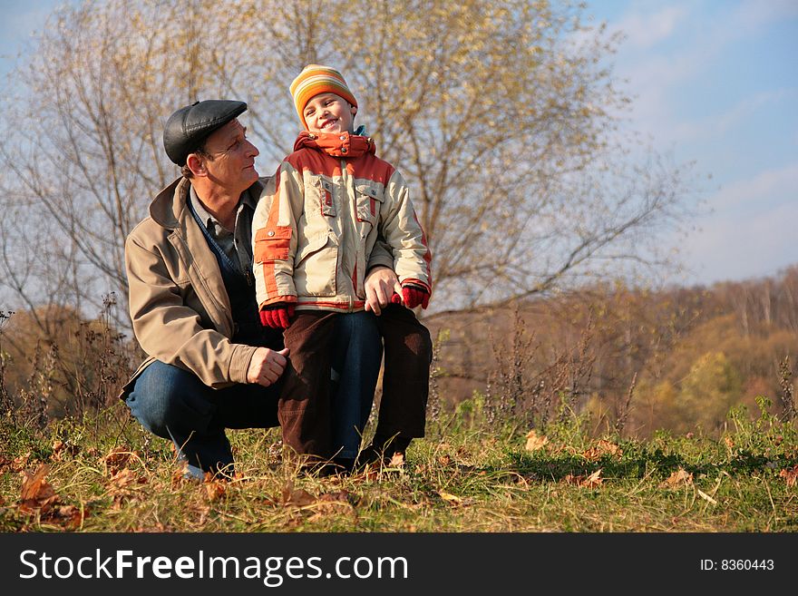 Grandfather and grandson in autumn wood. Grandfather and grandson in autumn wood