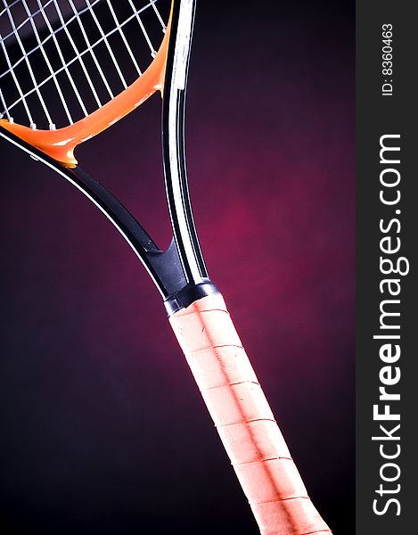 Close-up of a tennis racquet with red background