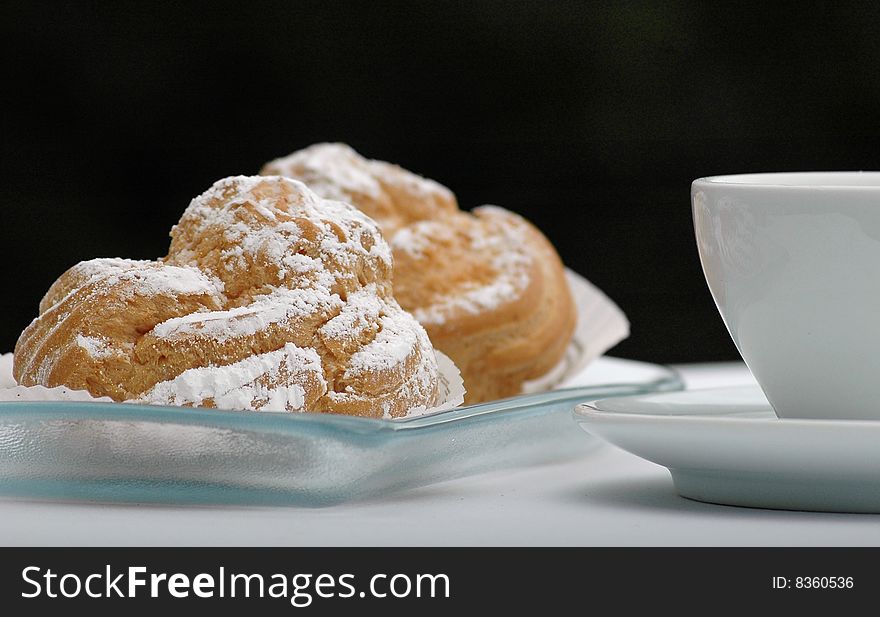 Pastries on a glass plate and white cup. Pastries on a glass plate and white cup