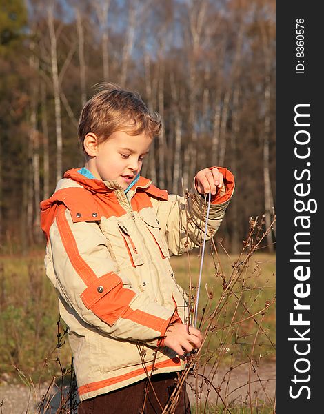 Boy in autumn wood with tape-line in hands