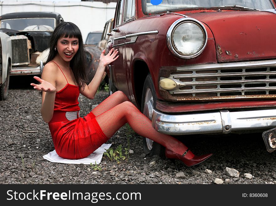 Girl beside retro car for constructions to wheel. Girl beside retro car for constructions to wheel