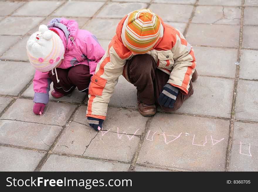 Two children with chalk on road, autumn