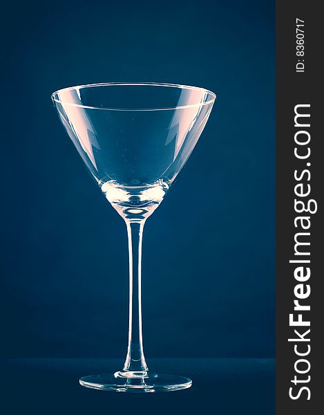 Empty martini glass on blue background
