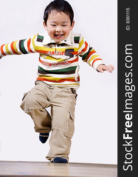 A picture of a little chinese boy jumping, laughing and having great fun himself. A picture of a little chinese boy jumping, laughing and having great fun himself