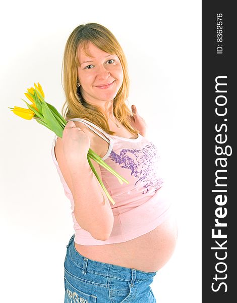 Young pregnant woman with yellow tulips on white. Young pregnant woman with yellow tulips on white