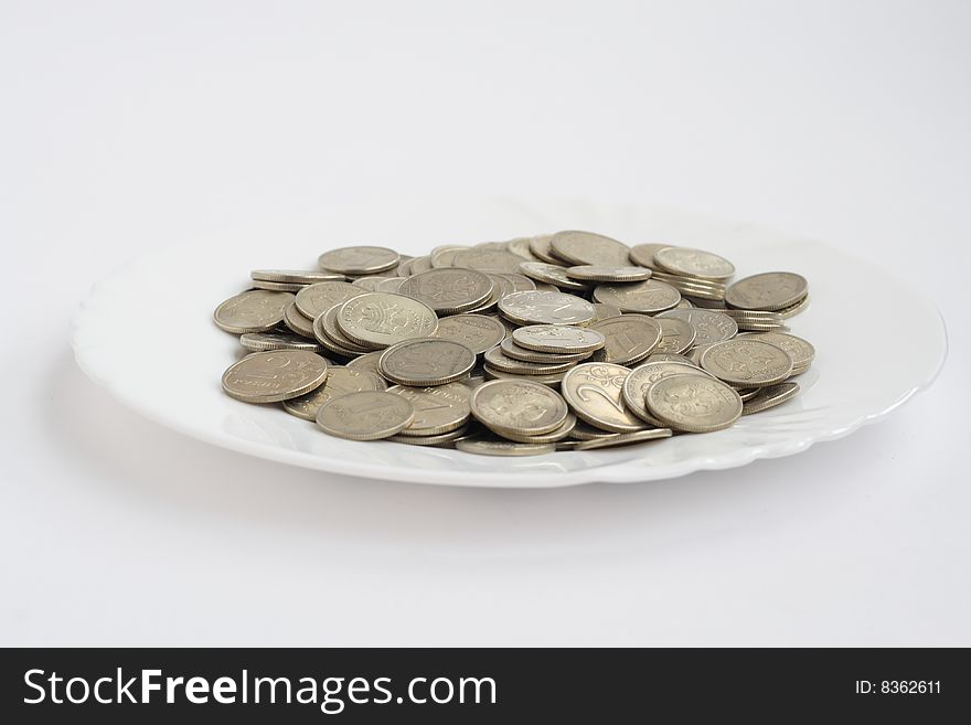 Plate with coins isolated on white background