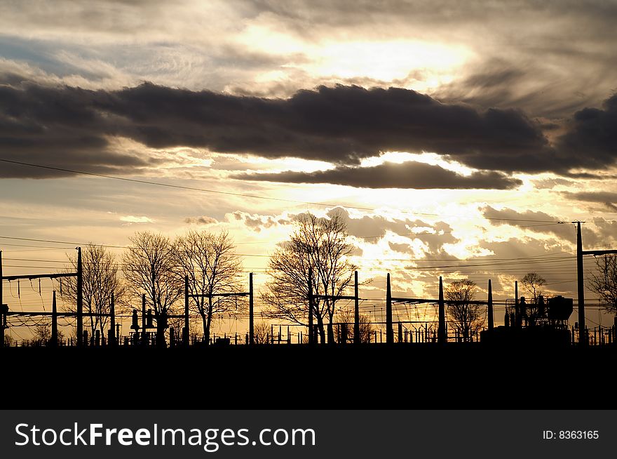 Dramatic sunset over electric substation silhouette