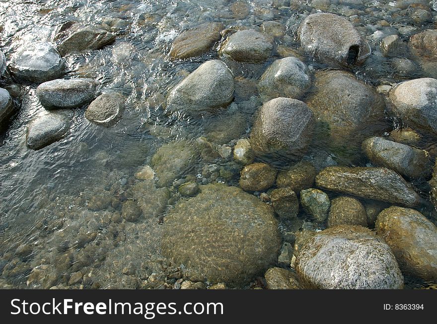 Much greater stones in transparent water of the river